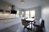 Moderne Küche mit ausreichend Platz für eine Sitzgelegenheit und mit Zugang zur Terrasse - Exklusives Einfamilienhaus mit zwei Vollgeschossen und Garage in Scheeßel
