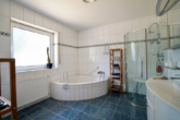 Badezimmer mit Eckbadewanne und bodentiefer Dusche