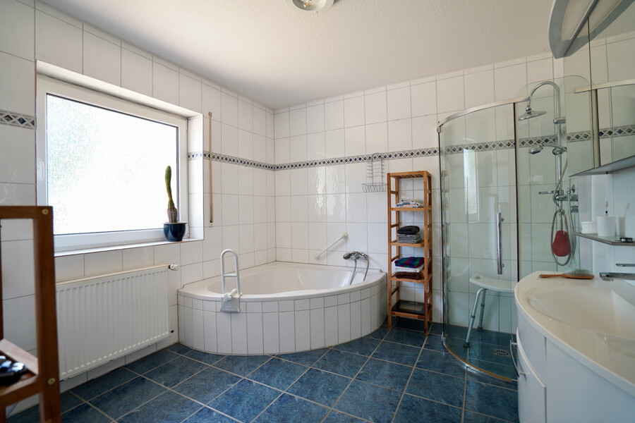 Badezimmer mit Eckbadewanne und bodentiefer Dusche