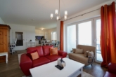 Wohn- und Esszimmer mit offener Küche und Zugang zum Balkon - Stilvolle 2-Zimmer-Wohnung im 2. Obergeschoss mit großem Balkon