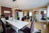 Esszimmer mit offenem Blick ins Wohnzimmer - Charmantes Einfamilienhaus mit überdachter Terrasse und Garage
