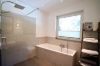 Badezimmer mit Badewanne und bodentiefer Dusche