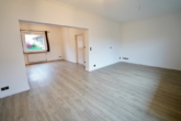Wohnzimmer mit offener Küche und Essbereich - Charmante 4-Zimmer-Wohnung mit Terrasse, zwei Balkonen und Carport